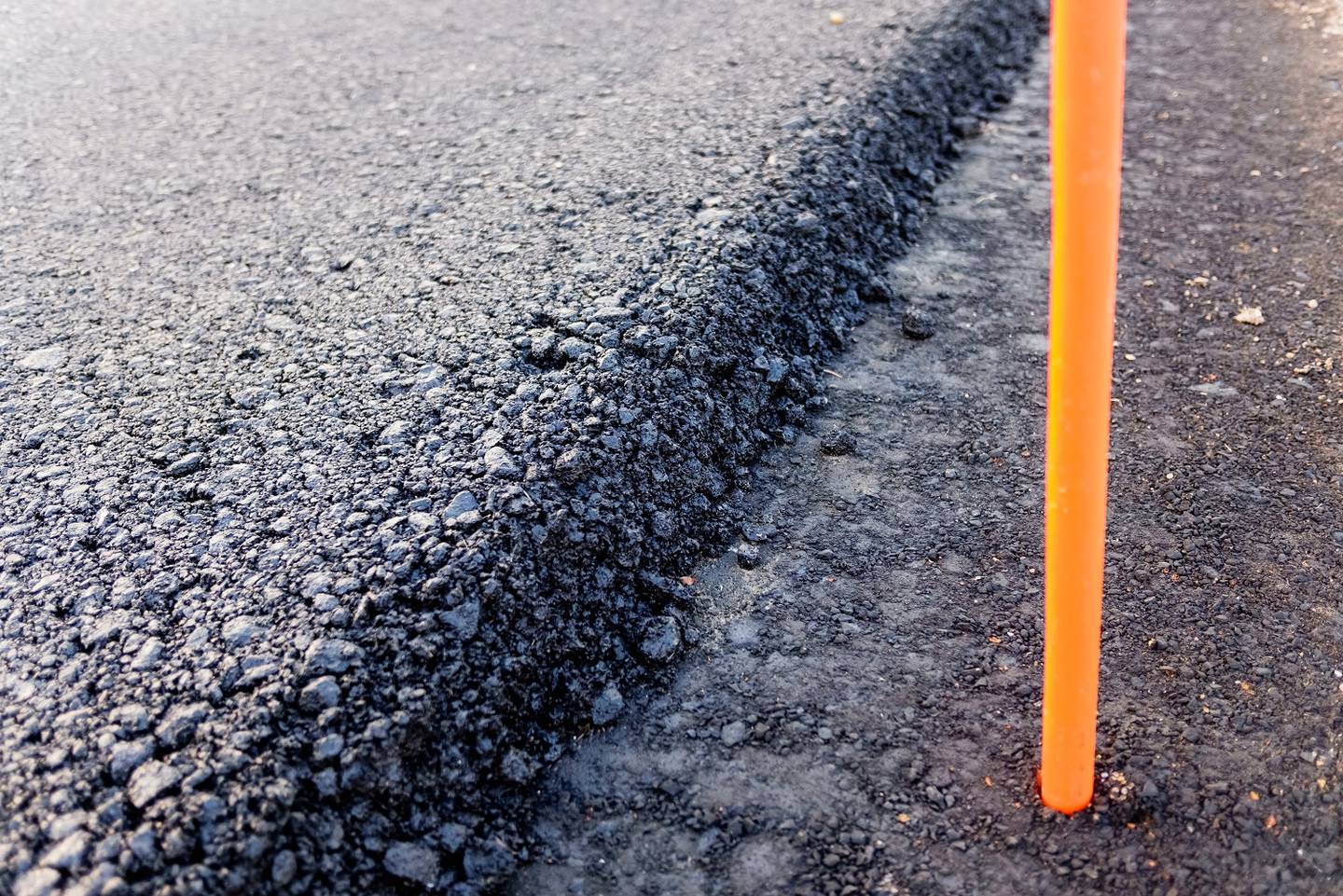 Close detail of the cut edge of a freshly paved asphalt mat