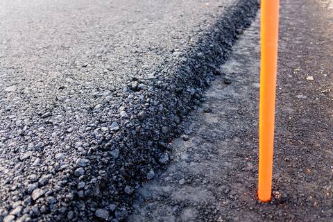 Close detail of the cut edge of a freshly paved asphalt mat