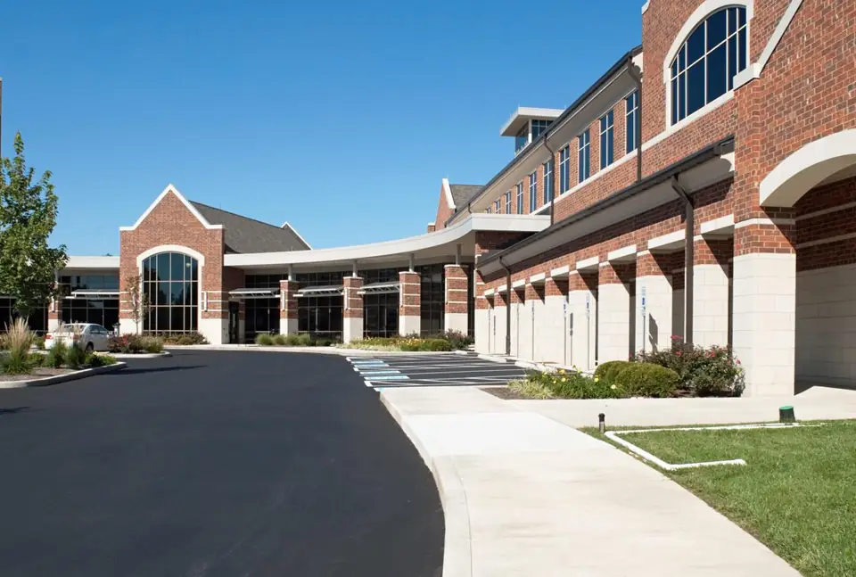A finished asphalt parking lot and drive at a commercial building