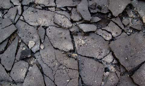 Cracked and deteriorated asphalt pavement in close crop