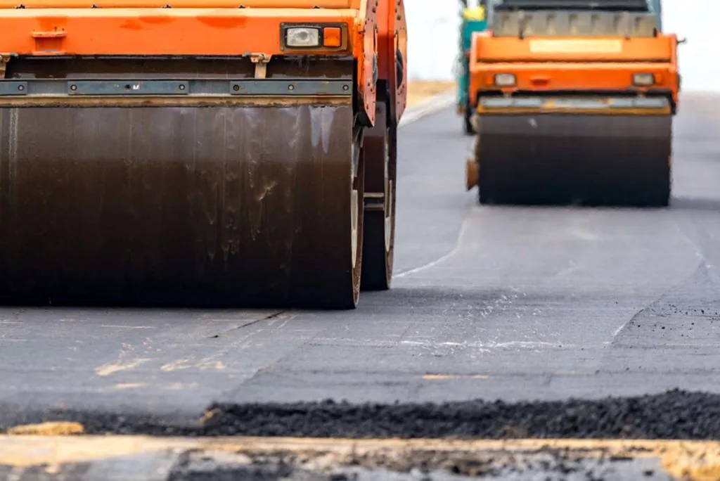 Rollers compacting a fresh asphalt surface