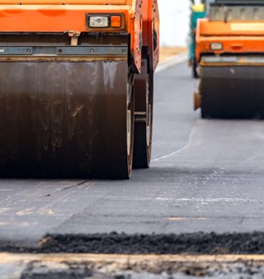 Close view on the road roller working on the new road construction site - Turnkey Asphalt