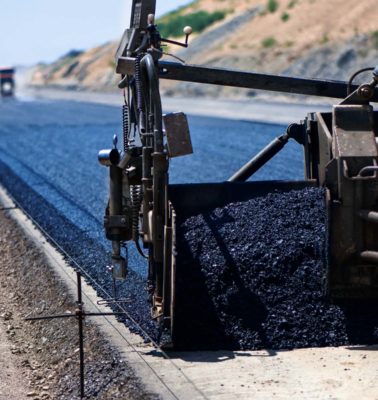 industrial pavement truck laying fresh asphalt on construction site - Turnkey Asphalt