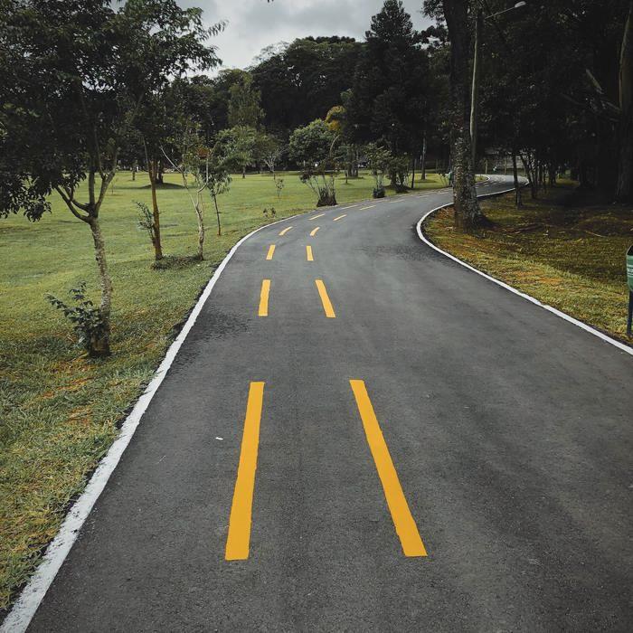 A finished asphalt drive curving through landscaped grounds