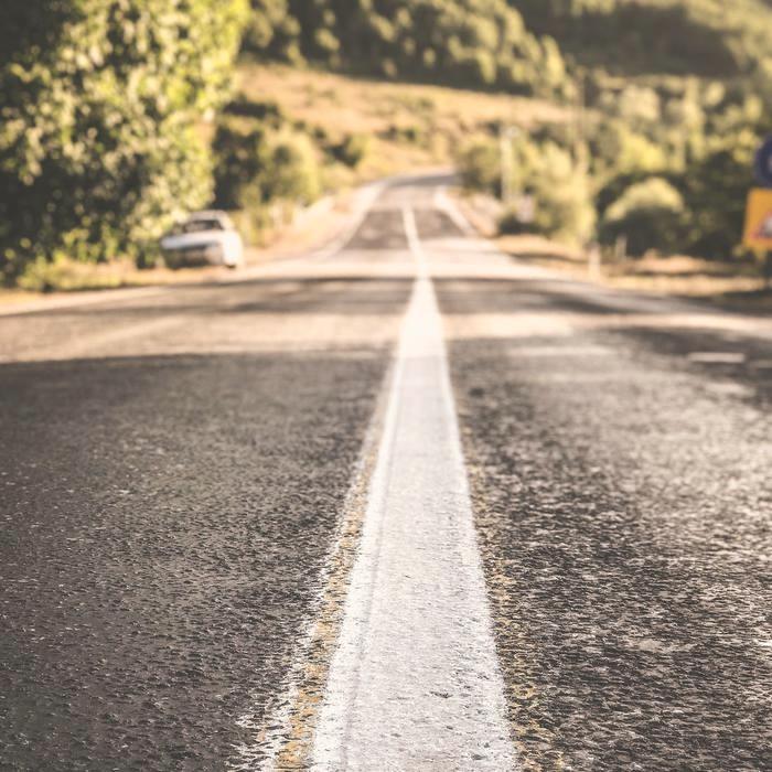 A completed asphalt surface carrying a crisp painted edge line