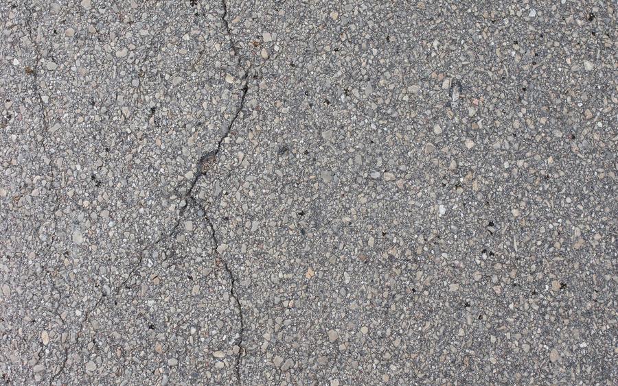 Cracking spreading across an aged asphalt surface