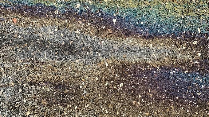 A worn industrial surface showing oil and wear